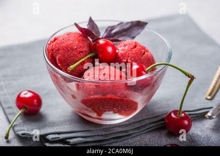 Palline di gelato al sorbetto di ciliegia biologica in vetro pronte a mangiare. Cibo biologico. Foto Stock