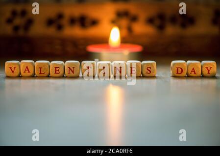 La parola felice il giorno di San Valentino di cubi di legno su un sfondo di legno. Foto Stock