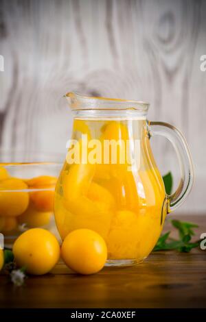 composta dolce cotta in un decanter di vetro di prugna matura di amarena, su un tavolo di legno Foto Stock