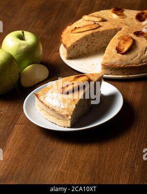 Pezzo di torta di mele vegana presentato su una tavola di legno. Foto Stock