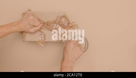 il nastro di imballaggio striato e sbriciolato sulla scatola di cartone non si è avvolto Foto Stock