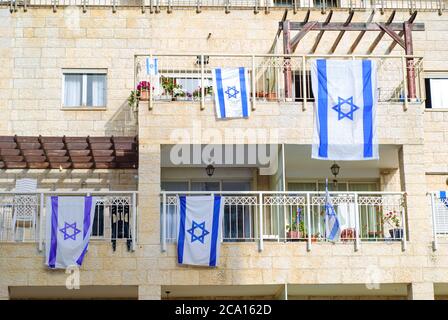 Lato anteriore della tipica casa israeliana con bandiere israeliane sulla finestra. Givat Shaul a Gerusalemme, Israele. Foto Stock