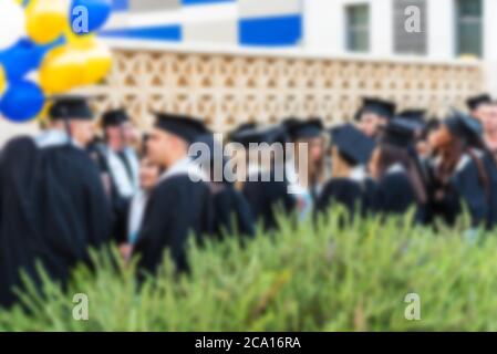 Immagine offuscata studenti universitari alla cerimonia di laurea.Gruppo felici più razze studenti in tavole di Malta e abiti di laurea outdor. Foto Stock