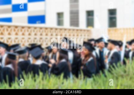 Immagine offuscata studenti universitari alla cerimonia di laurea.Gruppo felici più razze studenti in tavole di Malta e abiti di laurea outdor. Foto Stock