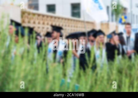 Immagine offuscata studenti universitari alla cerimonia di laurea.Gruppo felici più razze studenti in tavole di Malta e abiti di laurea outdor. Foto Stock