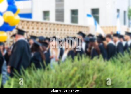 Immagine offuscata studenti universitari alla cerimonia di laurea.Gruppo felici più razze studenti in tavole di Malta e abiti di laurea outdor. Foto Stock