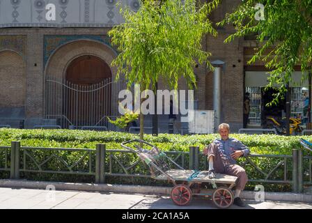 TEHERAN, IRAN - 22 MAGGIO 2017: Uomo seduto su un carrello vuoto per la strada di Teheran. Il tasso di disoccupazione iraniano sarà del 16% nel dicembre 2020, come riportato da Inte Foto Stock