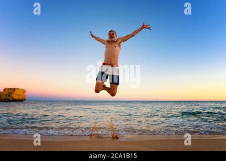 Uomo che salta alla spiaggia di Camilo, Portogallo Foto Stock