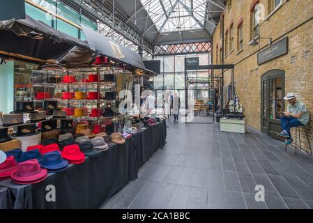 I venditori di Hat si trovano nel mercato di Spitalfields, Londra, Inghilterra, Regno Unito Foto Stock