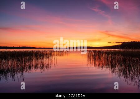 Il tramonto mozzafiato sulle acque calme del lago Foto Stock