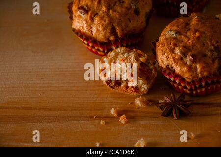 Muffin fatti in casa appena sfornati con uvetta e carote. Dolci vegetariani su sfondo di legno. Posiziona per il testo. Foto Stock