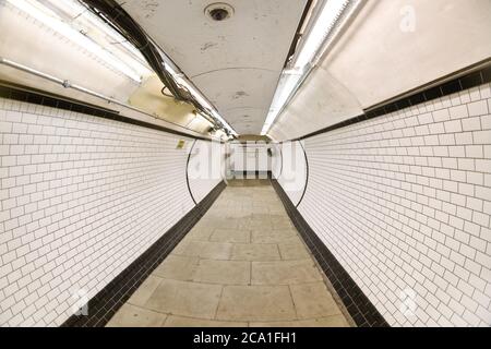 Londra, Regno Unito - 24 febbraio 2007: Foto grandangolare estrema (fisheye) del tunnel alla stazione della metropolitana di Londra che conduce alle piattaforme ferroviarie. Foto Stock