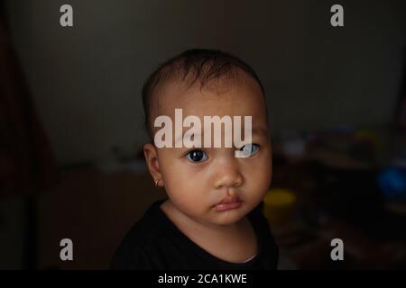 Un bel bambino indonesiano carino con un look pleading Foto Stock