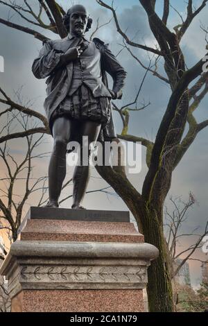 Statua di William Shakespeare (di John Quincy Adams Ward) che si trova nel Central Park di New York, vista del giorno della città con alberi, grattacieli e nuvole Foto Stock
