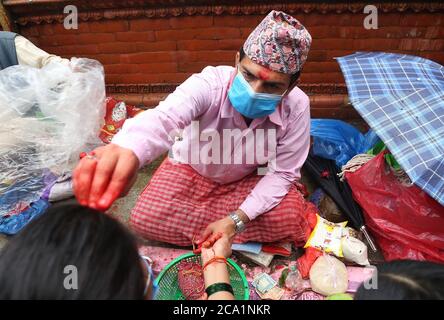 Kathmandu, Nepal. 3 agosto 2020. Un sacerdote offre tika sulla fronte dopo aver legato un filo sacro in celebrazione del festival di Janai Purnima in mezzo alla pandemia del virus corona in un tempio di Shiva a Kathmandu, Nepal. (Foto di Archana Shrestha/Pacific Press) Credit: Pacific Press Media Production Corp./Alamy Live News Foto Stock