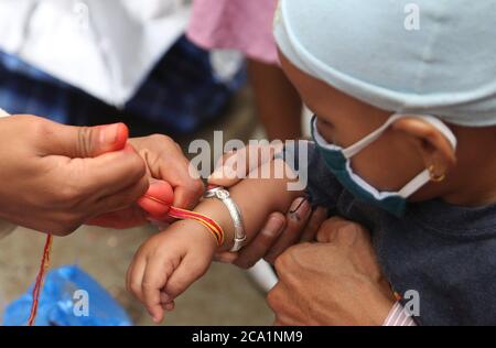 Kathmandu, Nepal. 3 agosto 2020. Un ragazzino guarda sopra come un prete lega un filo sacro a lui nella celebrazione del festival di Janai Purnima in mezzo alla pandemia del virus della corona ad un tempiale di Shiva in Kathmandu, Nepal. (Foto di Archana Shrestha/Pacific Press) Credit: Pacific Press Media Production Corp./Alamy Live News Foto Stock