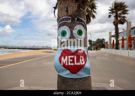 Melbourne Covid-19 2020. Maschera 'i love Melb' su un albero in una vuota St Kilda Beach a Melbourne Australia . Foto Stock