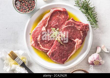Due costolette di manzo con spezie saline aglio al rosmarino in olio d'oliva - vista dall'alto Foto Stock