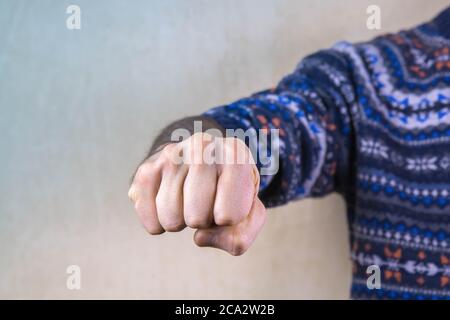 Il pugno dell'uomo si accanò con rabbia. Un uomo aggressivo con un pugno clenched minaccia di colpire. Concetto di violenza domestica o di genere. Primo piano, spazio di copia Foto Stock