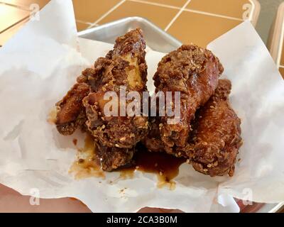 Ali di pollo con salsa Teriyaki e sesame al ristorante fast food. Pronto a mangiare. Foto Stock