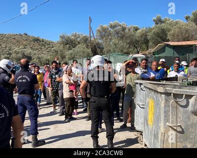 Moria, Grecia. 04 agosto 2020. Durante una visita del primo ministro della Renania Settentrionale-Vestfalia Laschet al campo profughi di Moria, le forze di sicurezza hanno protetto i rifugiati che hanno cantato 'Moria libera'. Laschet (CDU), Ministro Presidente della Renania Settentrionale-Vestfalia, sta visitando il campo profughi di Moria sull'isola di Lesbos come parte di una gita di diversi giorni in Grecia. Credit: Hülsmeier/dpa/Alamy Live News Foto Stock