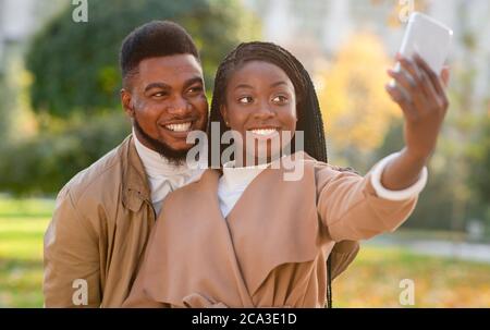 Coppia afro felice che prende auto-ritratto, catturando i loro momenti felici insieme Foto Stock