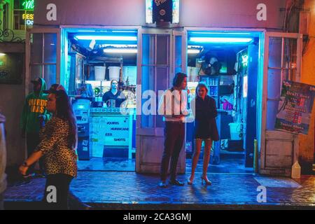 New Orleans - 05/01/2018: Vita notturna lungo Bourbon Street nel quartiere francese - adolescenti di fronte al negozio h24 Foto Stock