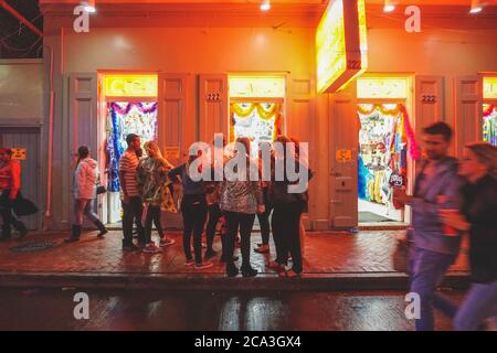 New Orleans - 05/01/2018: Vita notturna lungo Bourbon Street nel quartiere francese - persone di fronte a un negozio di sigari e abiti Foto Stock