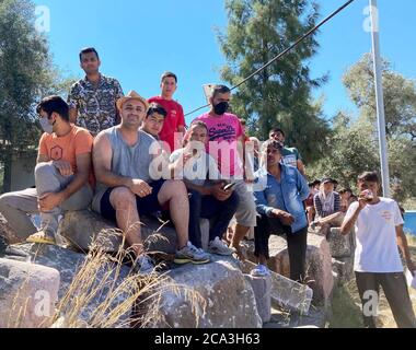Lesbos, Grecia. 04 agosto 2020. I rifugiati afghani siedono su pietre a Camp Kara Tepe. Laschet (CDU), primo ministro della Renania Settentrionale-Vestfalia, sta visitando il campo profughi sull'isola di Lesbos come parte di una gita di diversi giorni in Grecia. Credit: Hülsmeier/dpa/Alamy Live News Foto Stock