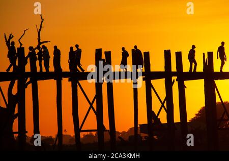 Persone che camminano attraverso il Ponte U-Bein al tramonto Foto Stock