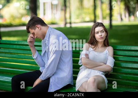 Turbato giovane coppia che ha un conflitto di famiglia sulla panchina al parco Foto Stock