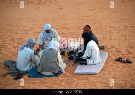 Parco Nazionale Algeria, Illizi, Tassili N'Ajjer: Gruppo di Tuareg relax nelle dune di sabbia di Tin Merzouga. Foto Stock