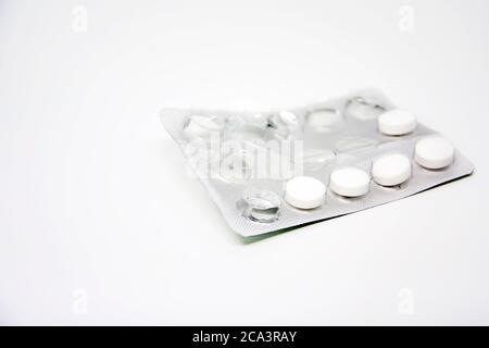 Una confezione blister usata con alcune pillole mancanti isolate su sfondo bianco. Medicinali e prodotti farmaceutici. Foto Stock