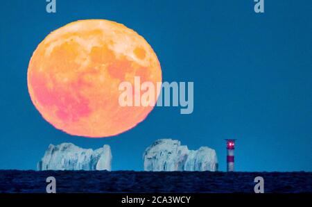 Gli aghi, Isola di Wight. 3 agosto 2020. Regno Unito Meteo. La luna piena di Sturgeon riempie il cielo sopra gli aghi sull'isola di Wight, dwarf il faro alto 31 metri. Credit Stuart Martin/Alamy Live News Foto Stock