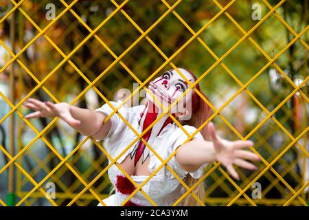 Ragazza a immagine di un orrore per la celebrazione di Halloween con il trucco di un clown denti penissuali e cupi di veleno, ritratto di un'utero pazzo Foto Stock