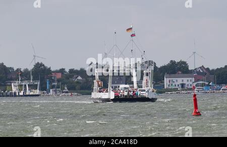 28 luglio 2020, Meclemburgo-Pomerania occidentale, Glegitz: Il traghetto 'Stahlbrode' naviga sopra lo Strelasund al largo dell'isola di Rügen. Il traghetto trasporta auto e passeggeri tra la terraferma della Pomerania occidentale e l'isola del Mar Baltico di Rügen. Lo Strelasund è un'insenatura del Mar Baltico e separa l'isola di Rügen dalla terraferma vicino a Stralsund. Il popolare traghetto di Rügen tra Glegitz su Rügen e Stahlbrode offre agli isolani e ai loro ospiti l'opportunità di "circumnavigare" gli incroci di traffico che sono soggetti a polvere in modo romantico durante l'arrivo e la partenza. Il tempo di viaggio i Foto Stock