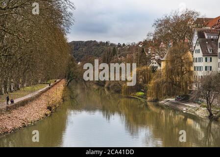 Vista sul fiume Neckar con tipiche case tedesche e l'isola di Neckarinsel. Gli edifici medievali e gli alberi senza foglie si riflettono sull'acqua al Neckarfront Foto Stock