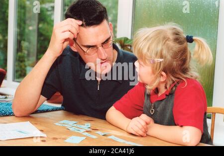 Padre che aiuta la figlia con abilità di alfabetizzazione MR UK Foto Stock