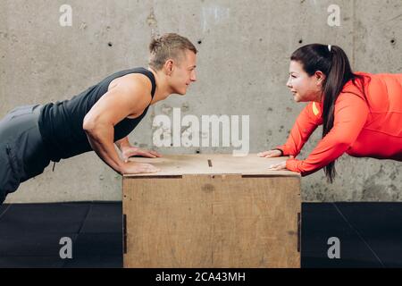 ragazzo piacevole aiutare la sua ragazza a perdere peso. primo piano vista laterale ritagliato foto. attività sportiva Foto Stock