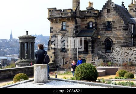 I visitatori si trovano di fronte all'Old Observatory House e al monumento Dugald Stewart sulla collina di Calton a Edimburgo, Scozia Foto Stock