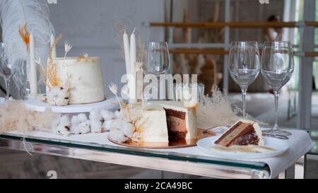 Bella torta di nozze cioccolato con crema di cioccolato all'interno e banana ripieno, pezzo di torta su un piatto. Torta bianca con decorazioni in cotone. Foto Stock