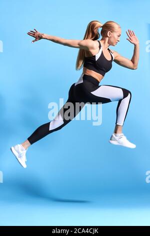 donna sportiva forte che partecipa alla competizione, sfondo blu isolato, studio shot.strength, corpo e cura della salute. benessere. Foto Stock