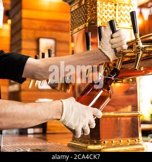 Versatore, riempimento bicchiere di birra, tazza Foto Stock