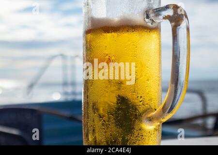 Birra fredda su una spiaggia in grande vetro Foto Stock