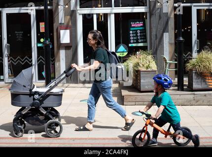 Sevenoaks, Kent, 4 agosto 2020, una donna che spinge un pram con un ragazzino sulla sua bicicletta fuori e circa a Sevenoaks, Kent. La previsione è per 20C sole con una brezza dolce ed è di ottenere più caldo come la settimana continua con temperature previste di 32C o più su Venerdì. Credit: Keith Larby/Alamy Live News Foto Stock