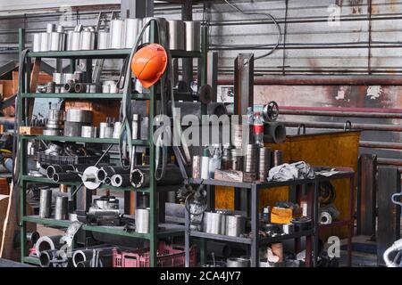 frammento di un interno industriale con stoccaggio di prodotti metallici e utensili sui ripiani dell'officina Foto Stock