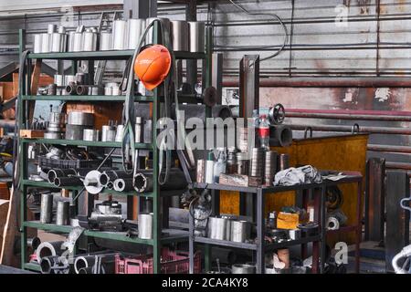 frammento di un interno industriale con stoccaggio di prodotti metallici e utensili sui ripiani dell'officina Foto Stock