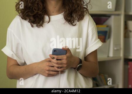 Moderna donna d'affari con telefono in mano e camicia oversize in ufficio. Spazio di copia Foto Stock