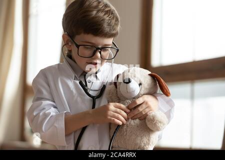 Adorabile ragazzino che gioca con il cane giocattolo. Foto Stock