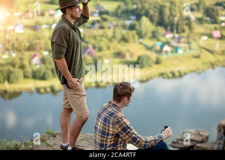 due viaggiatori che hanno una pausa dopo l'arrampicata su una montagna alta, vista laterale foto. turismo, viaggio, paesaggio incredibile sullo sfondo della foto Foto Stock